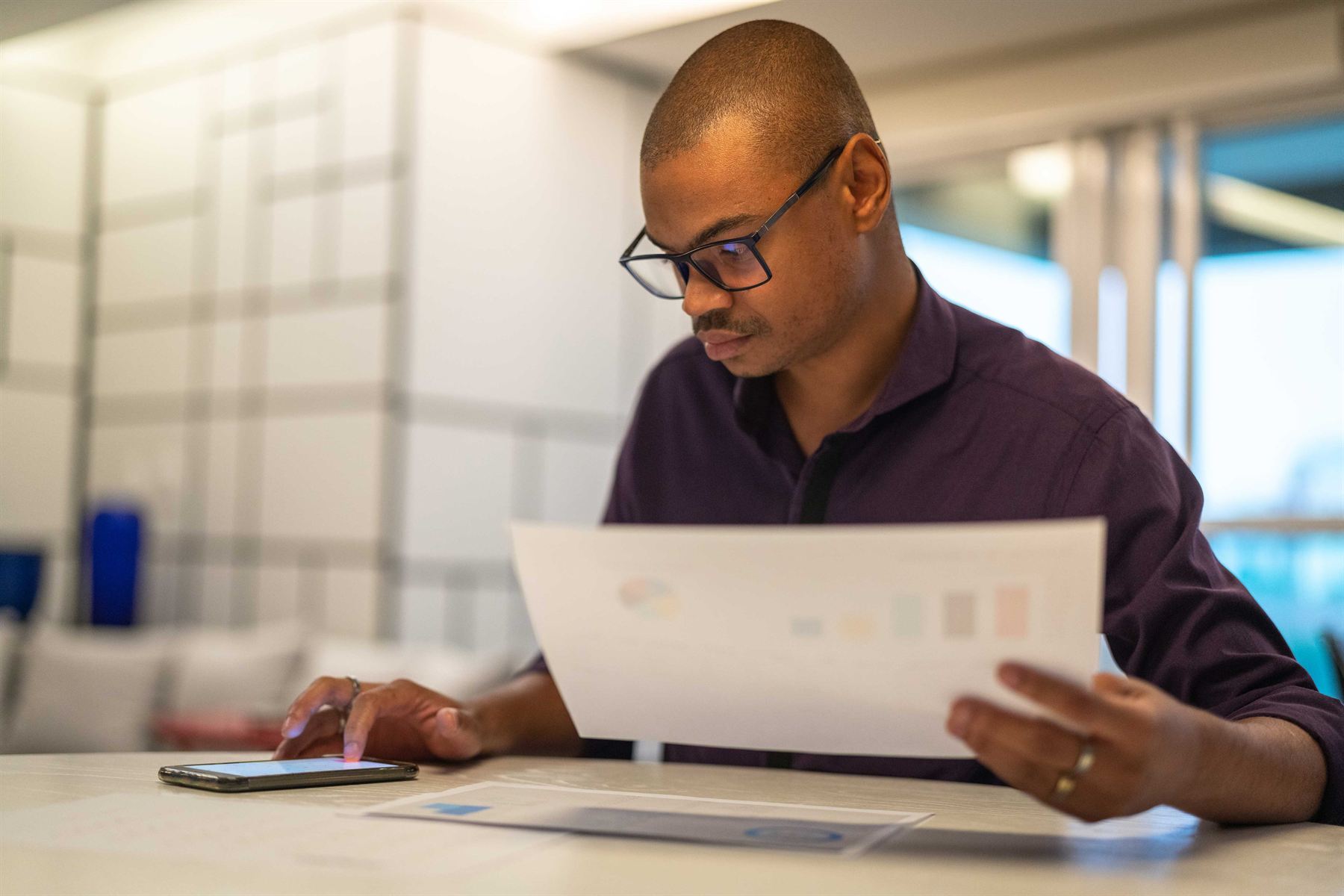 A man reviewing a printed document at his desk